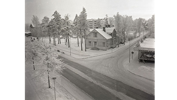 Näkymä Salpausselänkadun ja Koulukadun kulmauksesta tammikuussa 1969, jossa sijaitsi Ketomaan talo. Kyseiselle tontille rakennettiin Kouvolan uusi kaupunginkirjasto. Rakennustyöt aloitettiin syyskuussa 1970 ja kirjaston avajaisia vietettiin elokuussa 1971. Kuva: Eero Suikki
