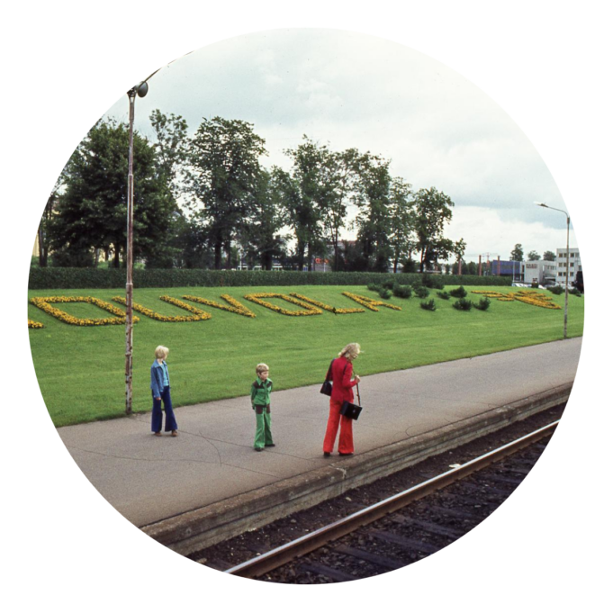 Ihmisiä kesäisen Kouvolan rautatieaseman laiturilla.