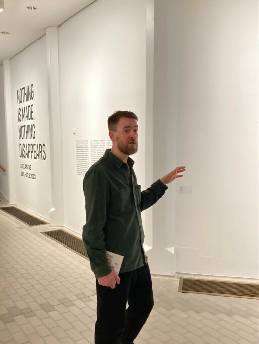 Axel Antas taidemuseossa lehdistötilaisuudessa. Taustalla näkyy näyttelyn nimi teipattuna museon seinään.