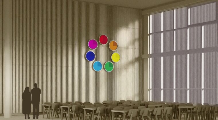Seinällä digitaalinen, pyöreä väriympyrä, jossa seitsemän eri väriä: punainen, oranssi, keltainen, vihreä, vaaleansininen, sininen ja violetti. Vasemmalla kaksi ihmistä katselee selin seinällä olevaa väriympyrää. Etualalla pöytiä tuoleineen.