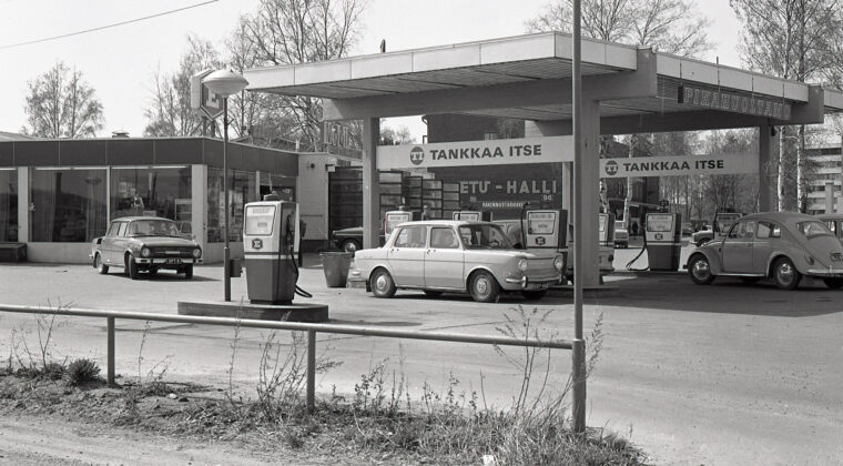 Autoja huoltoaseman pihalla tankkauspisteelle, jossa bensapumppuja eri bensiinilaaduille. Huoltamon rakennus vasemmalla. Etualalla dieselöljyn tankkauspiste. Takana näkyy Etu-Hallin rakennus.