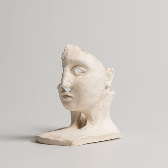 Veistoksessa osa ihmisen kasvoista.