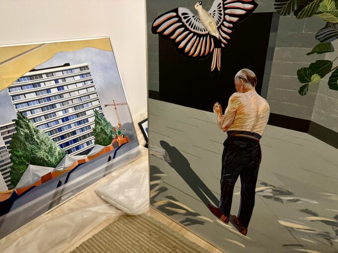 Kaksi suurikokoista maalausta nojaa seinään.